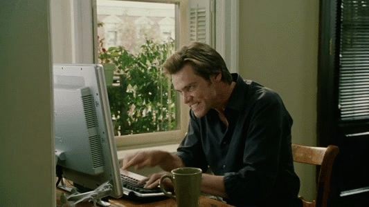 Homem digitando animado no computador, em frente a uma janela