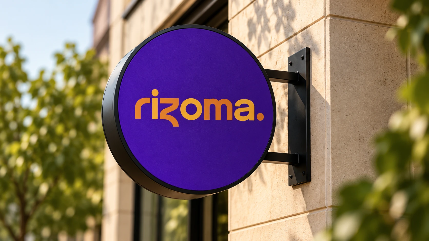 Placa redonda na fachada de um prédio, com o logotipo rizoma. em amarelo sobre fundo violeta