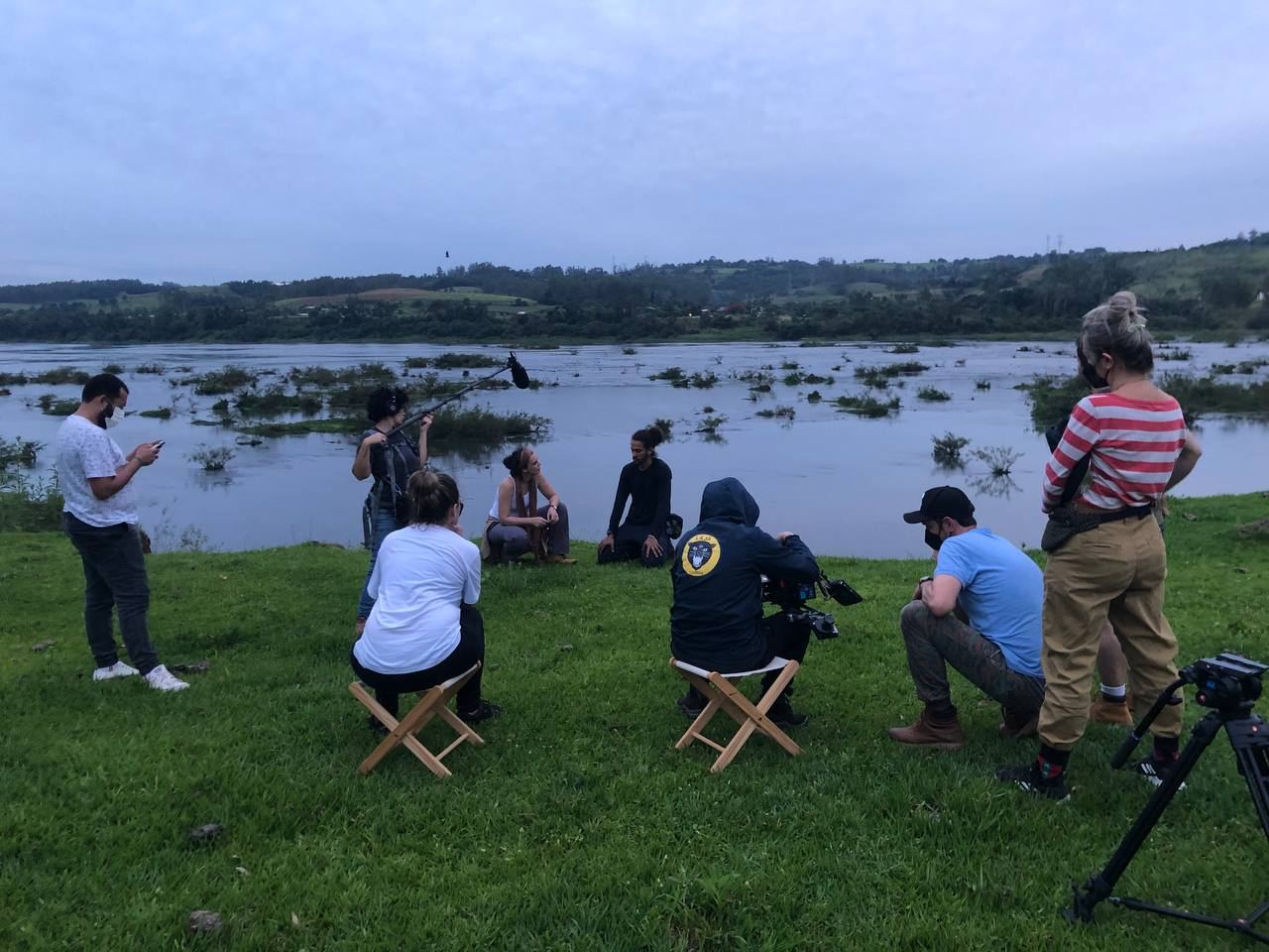 Equipe de filmagem grava uma entrevista à beira de uma represa