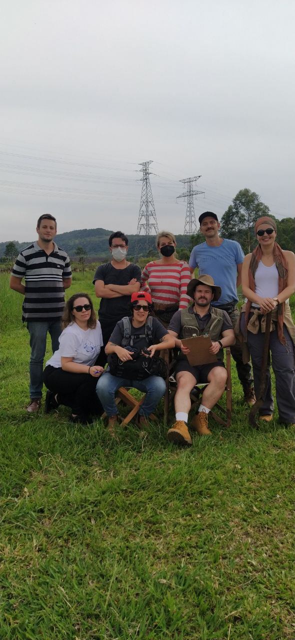 Parte da equipe do filme reunida em um campo