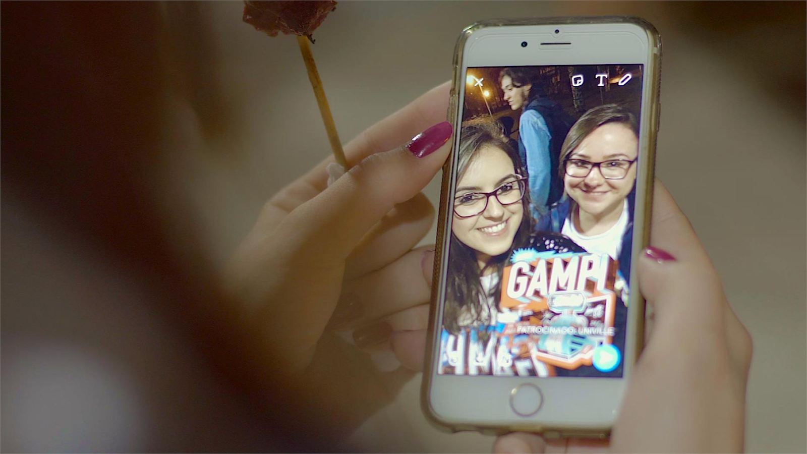 Celular exibindo selfie de estudantes com filtro da Univille